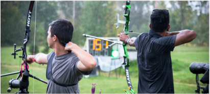 Archers on the line with an ArcheryClock LED scoreboard showing countdown and lane indicators